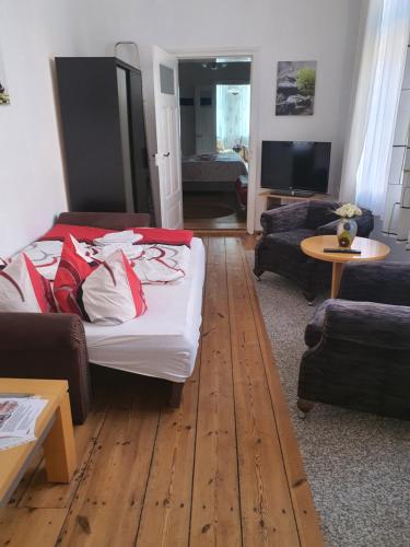 ein Wohnzimmer mit einem Bett, einem Sofa und einem Tisch in der Unterkunft Große Ferienwohnung 85qm in Havelberg