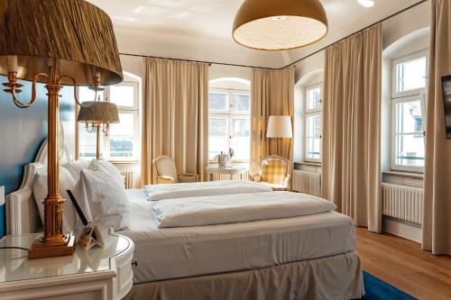 Un dormitorio con una cama grande y una mesa con una lámpara. en Hotel & Restaurant Posthalterei en Zusmarshausen