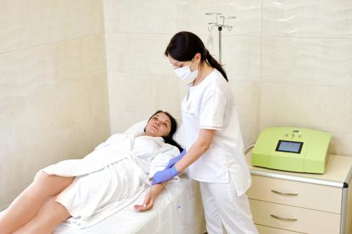 a nurse standing next to a woman in a bed at СПА-Готель "RESPECT" in Skhidnitsa