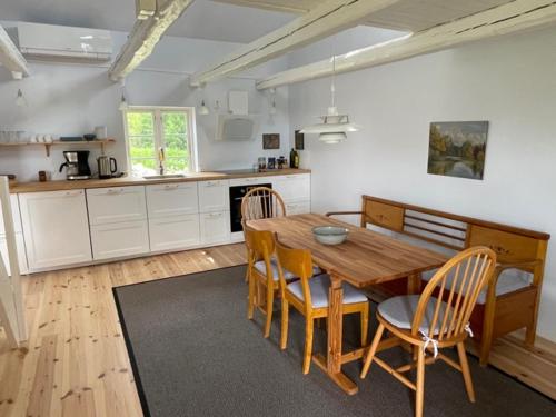 a kitchen with a wooden dining table and chairs at Brogård - gårdlejlighed in Agunnaryd