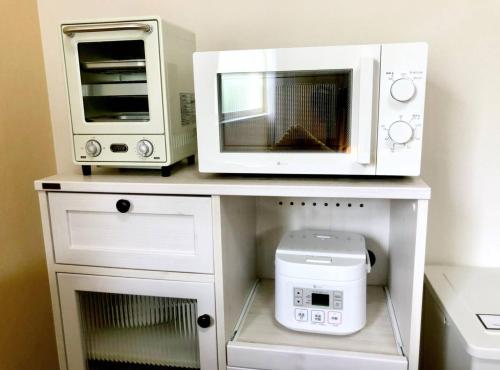 two microwaves and a microwave on a table at グレース大磯 in Oiso