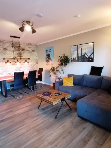 uma sala de estar com um sofá azul e uma mesa em Haus Sonnenkur em Heusweiler