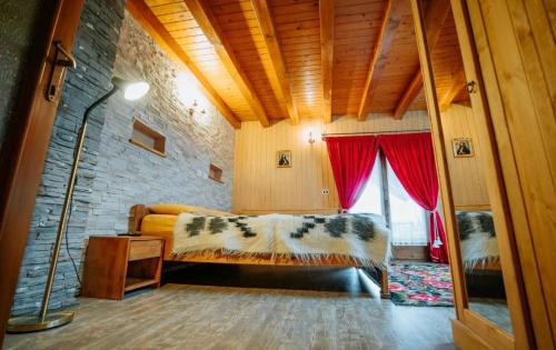 a bedroom with a bed and a brick wall at Casa DAVIDEN in Moisei