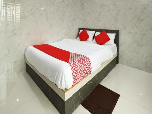 a bedroom with a bed with red pillows on it at Guru Comforts Belur in Belūr