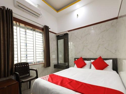 a bedroom with a large bed with red pillows at Guru Comforts Belur in Belūr