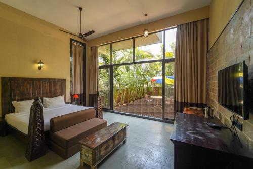 a bedroom with a bed and a tv and a couch at Triose Boutique Hotel Lonavala in Lonavala