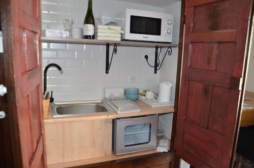 Il comprend une petite cuisine équipée d'un évier et d'un four micro-ondes. dans l'établissement Ô Sources, à Bazenville