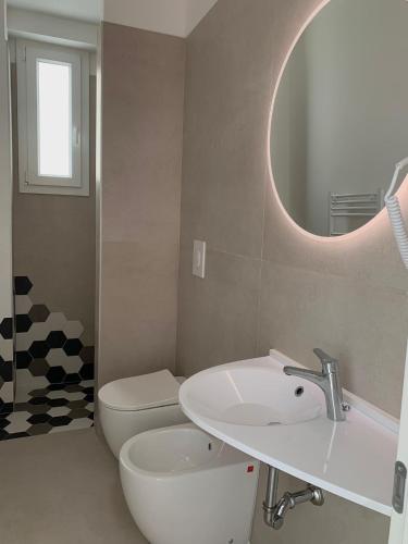 a bathroom with a sink and a toilet and a mirror at Appartamento Gardenia Deluxe in Sannicola