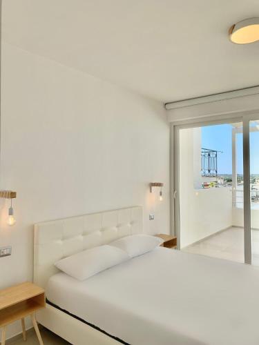 a white bedroom with a white bed and a window at Appartamento Gardenia Deluxe in Sannicola