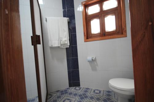 baño con aseo y ventana en Hotel Tres Marías, en San Cristóbal de Las Casas
