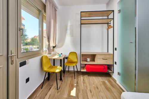 a room with two yellow chairs and a desk at City Experience Apartments A in Heraklio Town
