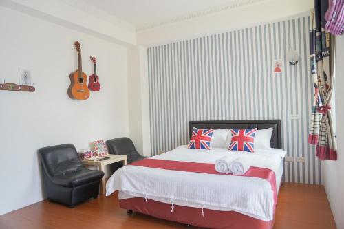 a bedroom with a bed and a chair and a guitar at Steps in Taitung in Taitung City