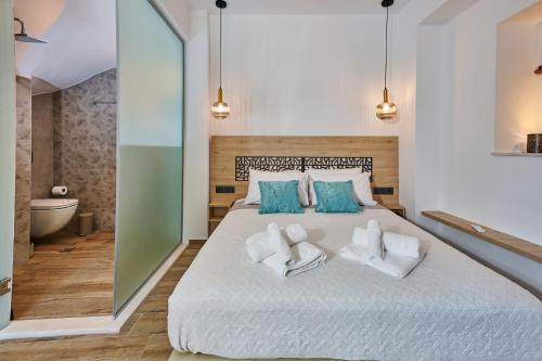 a bedroom with a large bed with blue and white pillows at City Experience Apartments A in Heraklio Town