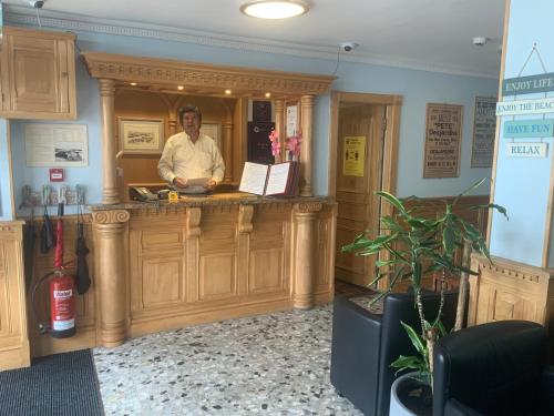 a man standing at a counter in a barber shop at Marina Metro Hotel in Saint Helier Jersey