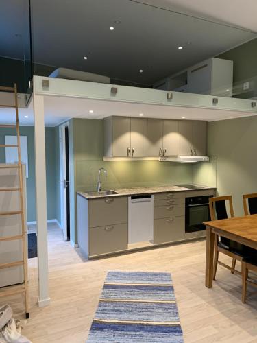 an open kitchen with a table and a counter top at Stuga Kaptenis Skrea strand in Falkenberg