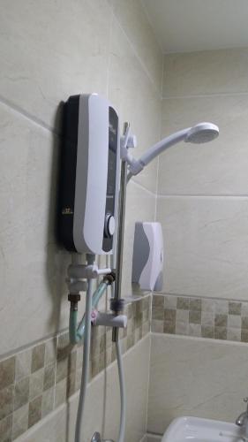 a phone on the wall of a shower in a bathroom at Om Hotel in Simpang Ampat