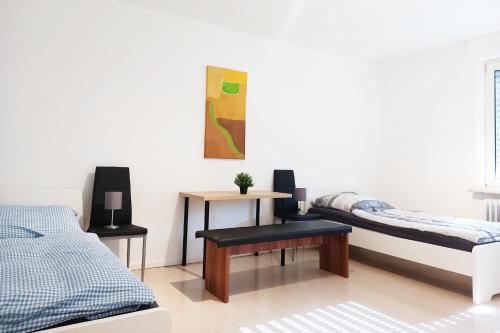 a white room with two beds and a table at Work & Stay Apartment mit TV & WLAN in Kleve