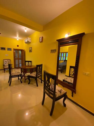 a room with a mirror and a table and chairs at Sharad Baug homestay in Bhuj