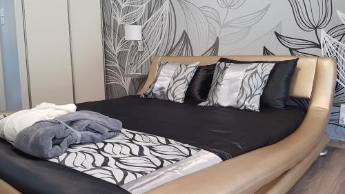 a bed with black and white sheets and pillows at Fred et Jules in Beaulieu-sur-Dordogne