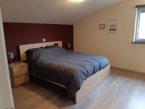 um quarto com uma cama grande e uma mesa de cabeceira em Hoevetoerisme Op 't Zand em Neerpelt