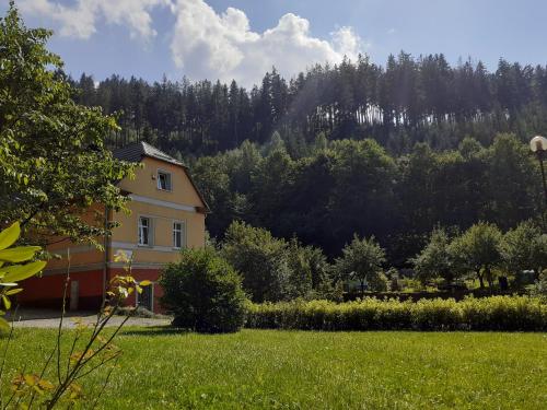 ein Haus inmitten eines Feldes mit Bäumen in der Unterkunft Na Skraju in Duszniki-Zdrój
