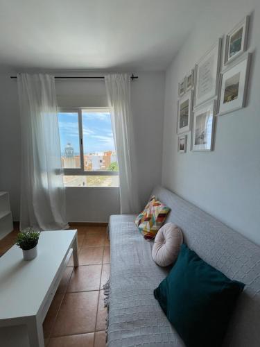 - un salon avec un canapé et une fenêtre dans l'établissement Apartamento y Piso frente al mar con vistas en Garrucha, à Garrucha