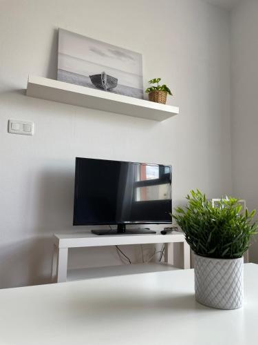 un televisor sentado en la parte superior de una mesa blanca en Apartamento y Piso frente al mar con vistas en Garrucha en Garrucha
