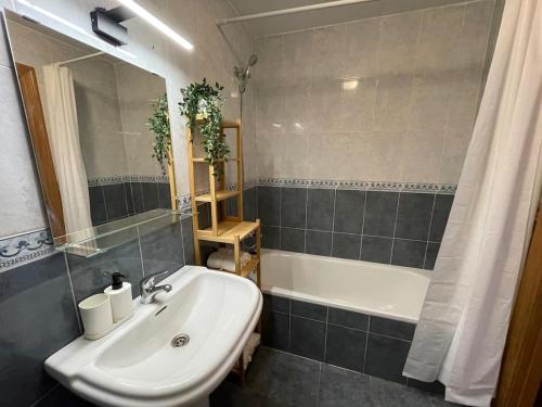 a bathroom with a white sink and a bath tub at Apartamento y Piso frente al mar con vistas en Garrucha in Garrucha