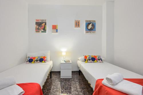 due letti in una stanza con pareti bianche di Apartamento Centric para 6 cerca de a playa y el tren a Premiá de Mar