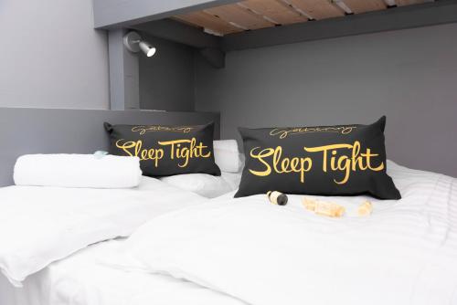 a bed with two black and gold pillows on it at Wrexham Central Stay - Apartment Six in Wrexham