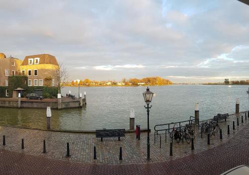 een uitzicht op een waterlichaam met een bank en fietsen bij All Exclusive Apartments in Dordrecht