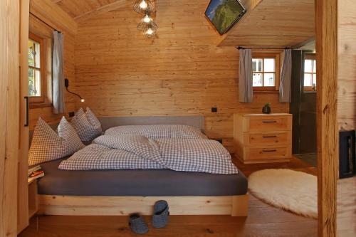 una camera con un letto in una cabina di legno di Das Alm-Chalet-Chiemsee a Bernau am Chiemsee