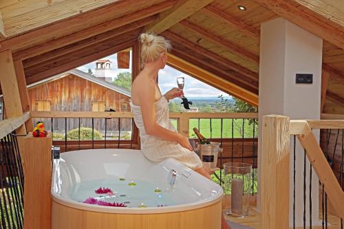 a woman standing in a bath tub in a house at Das Alm-Chalet-Chiemsee in Bernau am Chiemsee