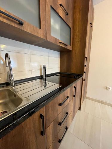 - une cuisine avec des placards en bois et un évier dans l'établissement Prestige Apartment Teslic, à Teslić