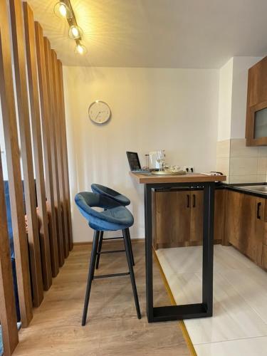 a table with a blue stool in a kitchen at Prestige Apartment Teslic in Teslić