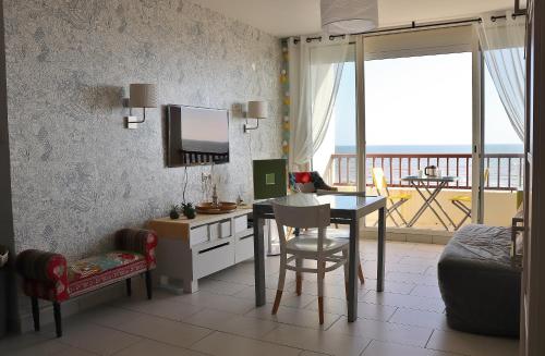 uma sala de estar com uma mesa e uma sala de jantar em Studio Front de Mer em Saint-Jean-de-Monts
