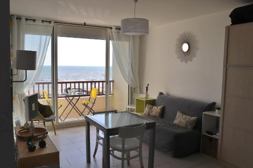 a living room with a couch and a view of the ocean at Studio Front de Mer in Saint-Jean-de-Monts