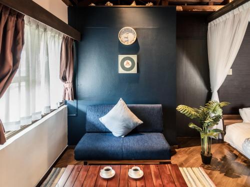 a living room with a blue chair and a bed at ザ・ビーチテラスホテルアオ石垣 in Ishigaki Island