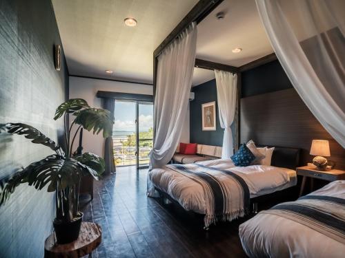 una habitación de hotel con 2 camas y una maceta en ザ・ビーチテラスホテルアオ石垣, en Ishigaki Island