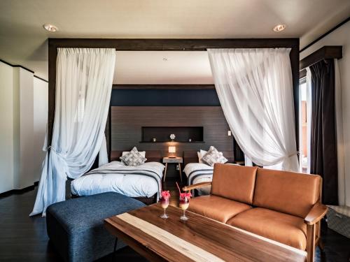 a hotel room with two beds and a couch at ザ・ビーチテラスホテルアオ石垣 in Ishigaki Island