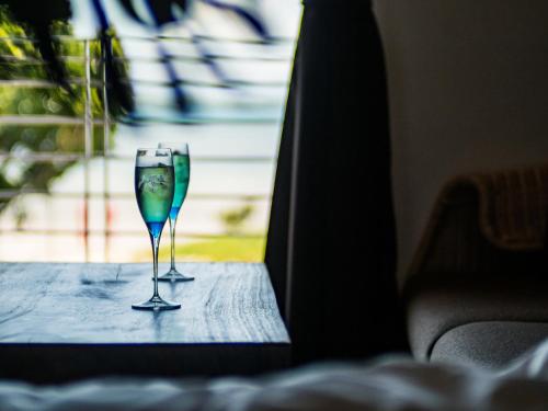 a pair of wine glasses sitting on a table at ザ・ビーチテラスホテルアオ石垣 in Ishigaki Island