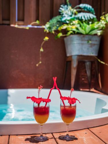 two wine glasses sitting on a table next to a pool at ザ・ビーチテラスホテルアオ石垣 in Ishigaki Island