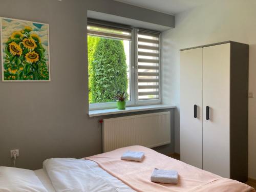 ein Schlafzimmer mit einem Bett und einem Fenster mit Handtüchern darauf in der Unterkunft Hostel Karpacki Szymon Szczepan in Zarszyn