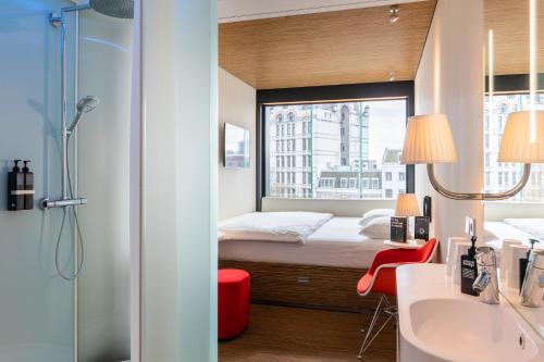 
a hotel room with a bed and a shower at citizenM Rotterdam in Rotterdam
