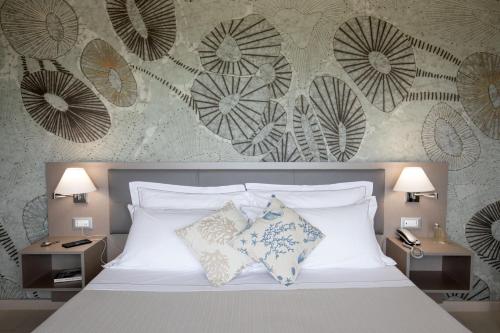 a bedroom with a white bed with two night stands at Hotel Miramare in Latina