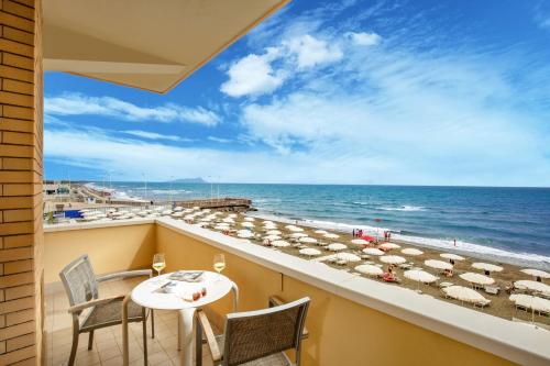 a balcony with a table and chairs and a view of the beach at Hotel Miramare in Latina
