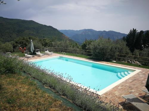 una gran piscina azul con montañas en el fondo en casa marconi, en Vetriano