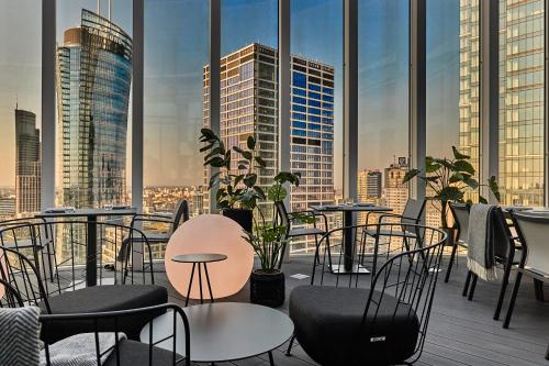 a balcony with tables and chairs and a view of a city at Holiday Inn Express - Warsaw - The HUB by IHG in Warsaw