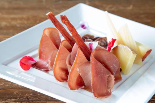 a plate of food with meat and bacon on it at Hotel Miramare in Latina