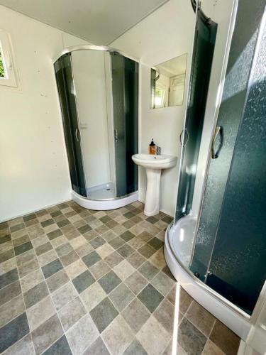 a bathroom with a shower and a sink at Forest Glamping in Braşov